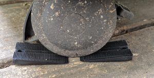 Showing a wheel on a grill with two Wobble Wedge plastic shims to stop the wheel from rolling, ie chock blocks